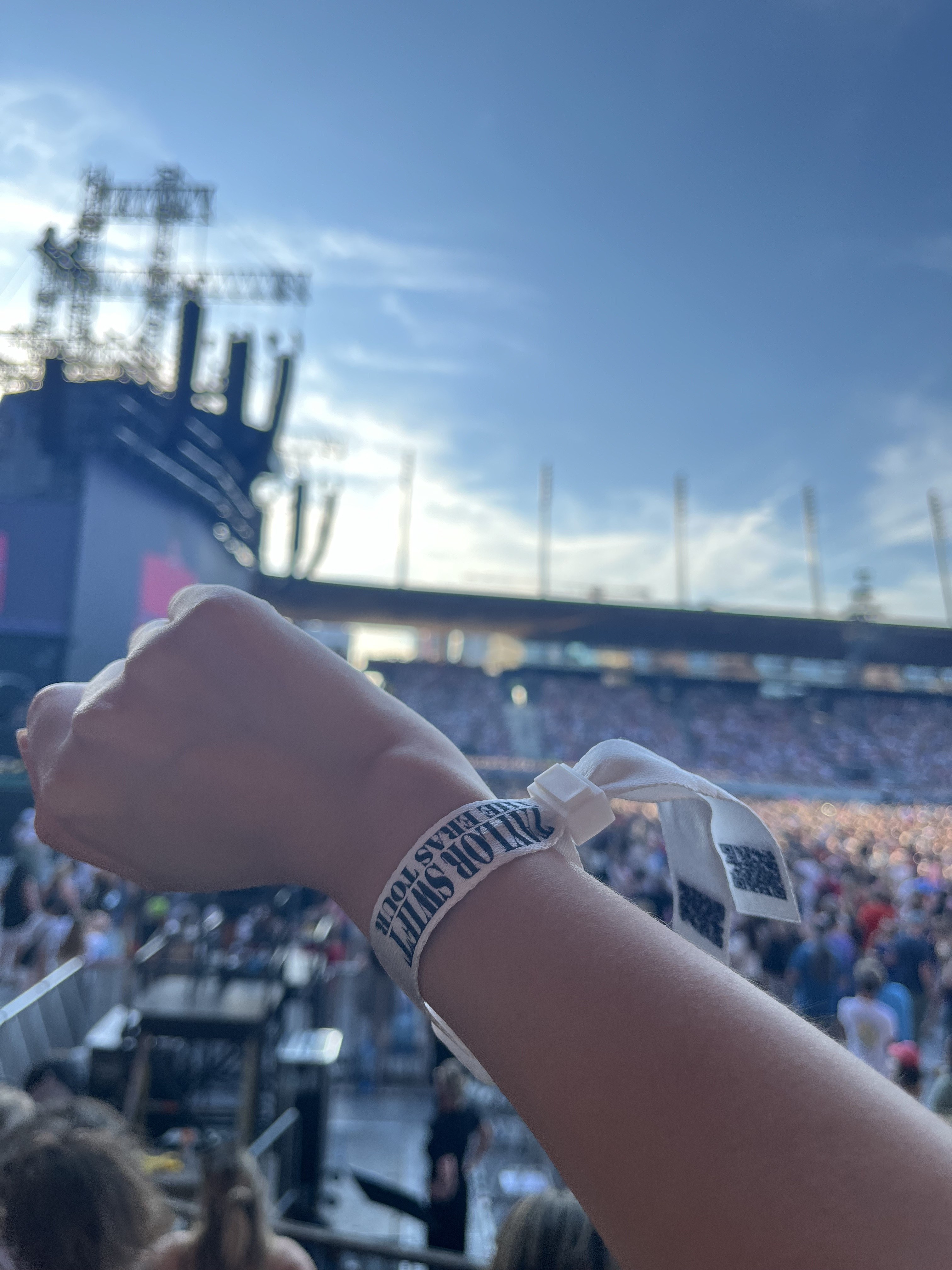 Taylor Swift Eras Tour wristband raised above the crowd, Zurich stadium