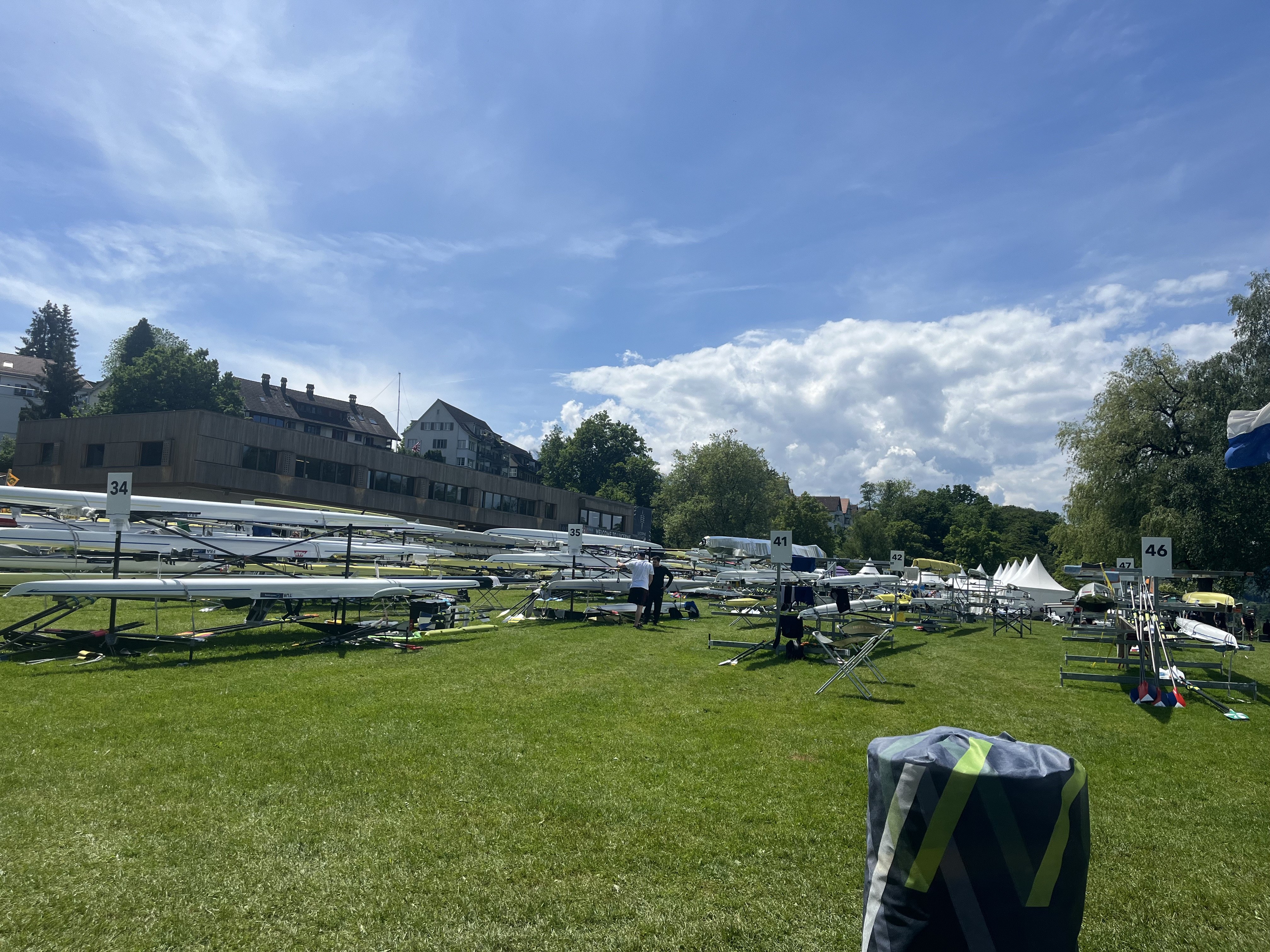 Numbered rowing shells racked on the grass at Rotsee